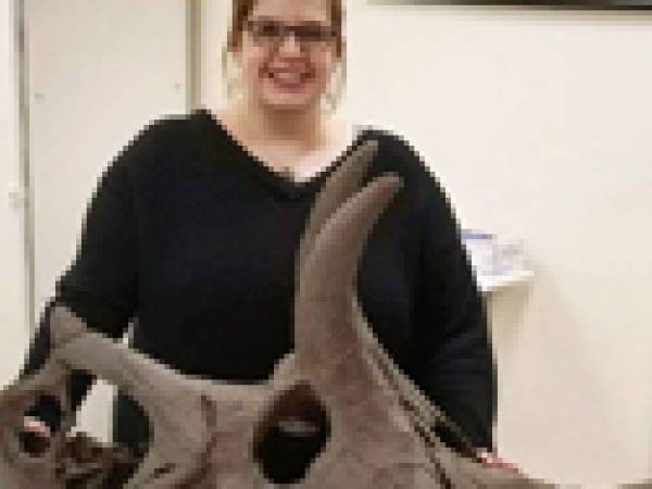 Dr. Morhardt stands behind a ceratopsian skull