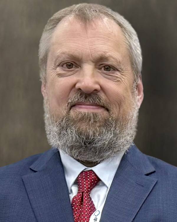 Headshot of Nathan Wilkens wearing a dark blue suit and maroon tie.