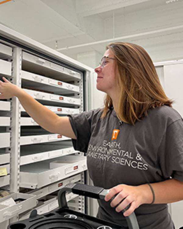 Hannah Maddox standing by shelves