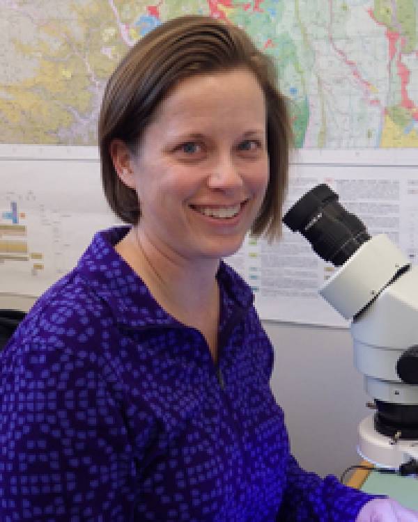 Amanda Person sitting by a microscope