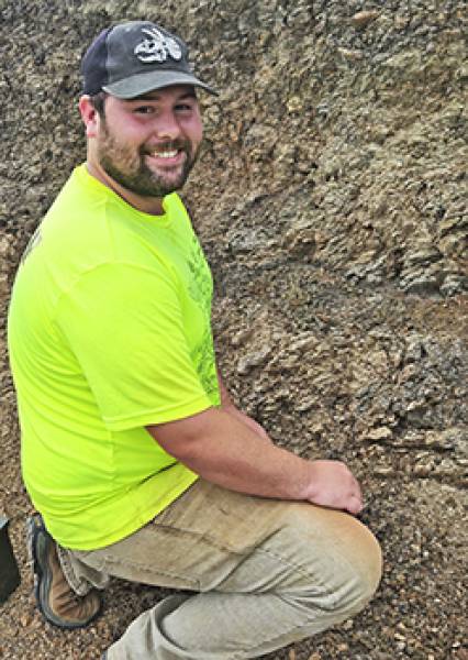 Skylor kneeling in the dirt