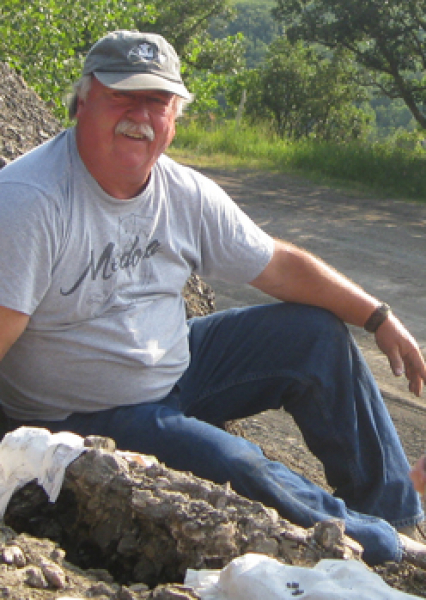 John sitting on a rock by a creek