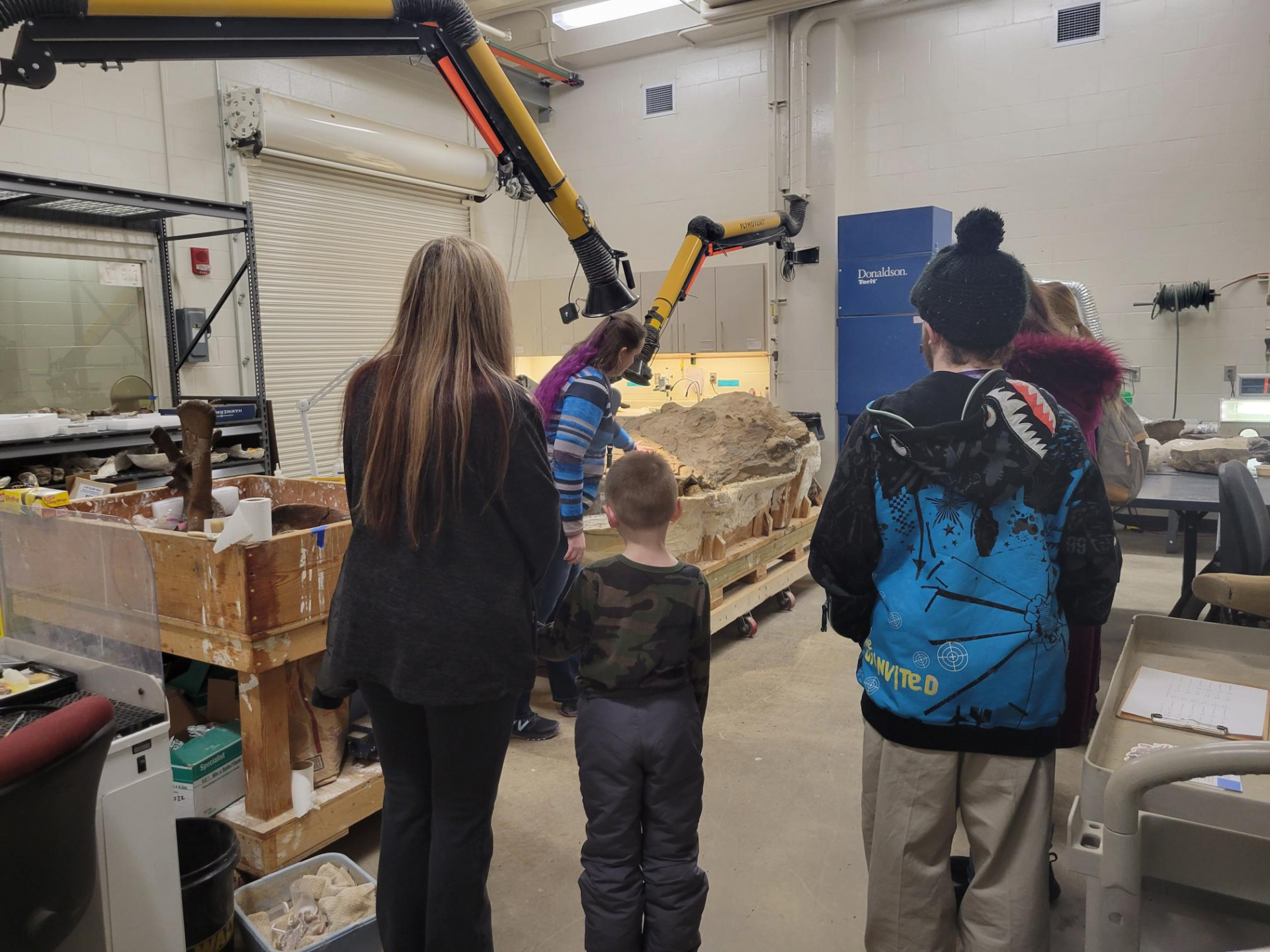 People surrounding the dinomummy block while on a tour