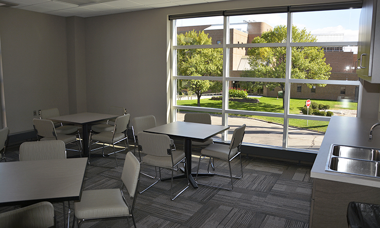 Break room with tables, chairs and a sink