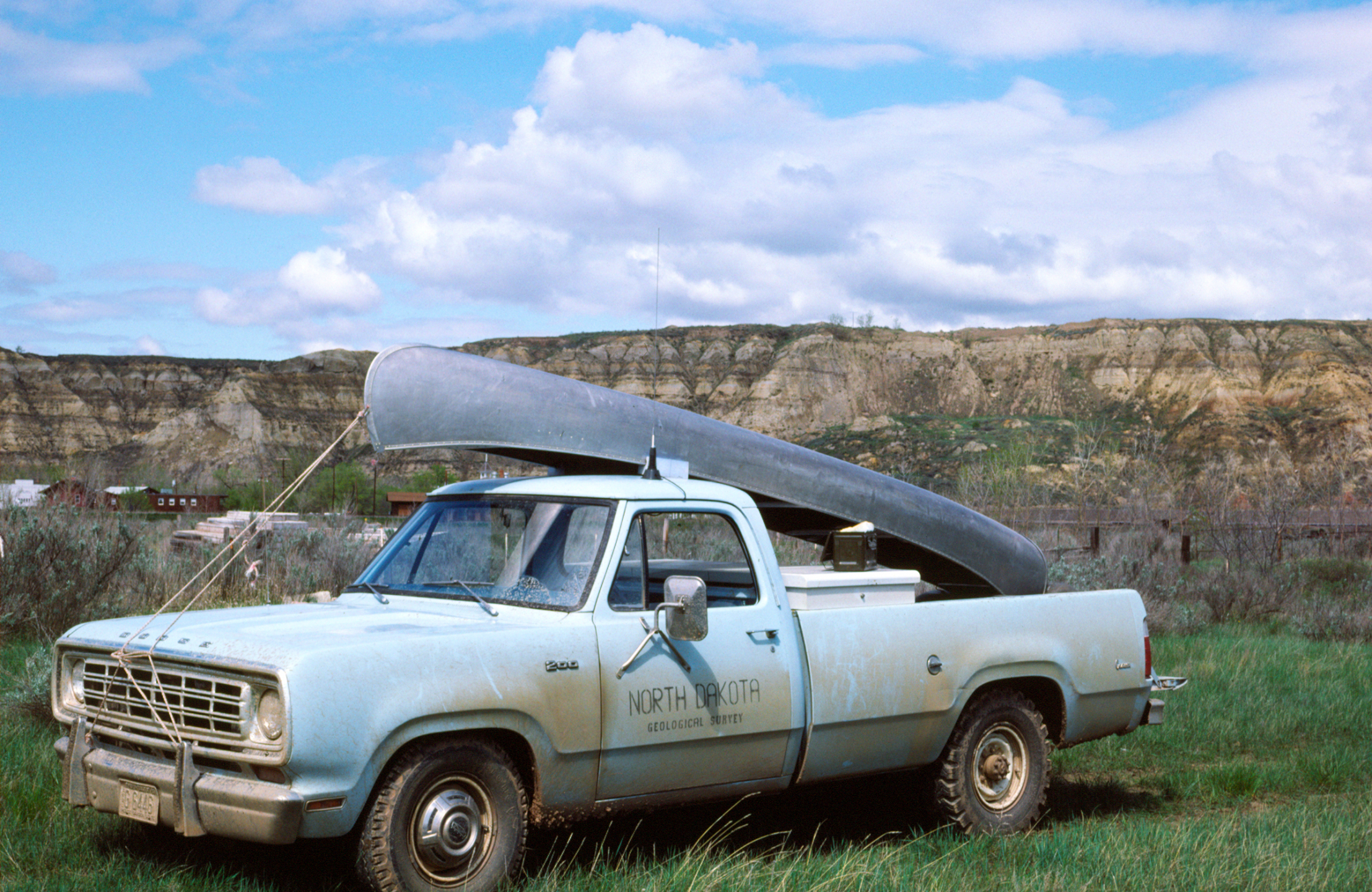 Photo of a truck with a canoe in the Badlands.