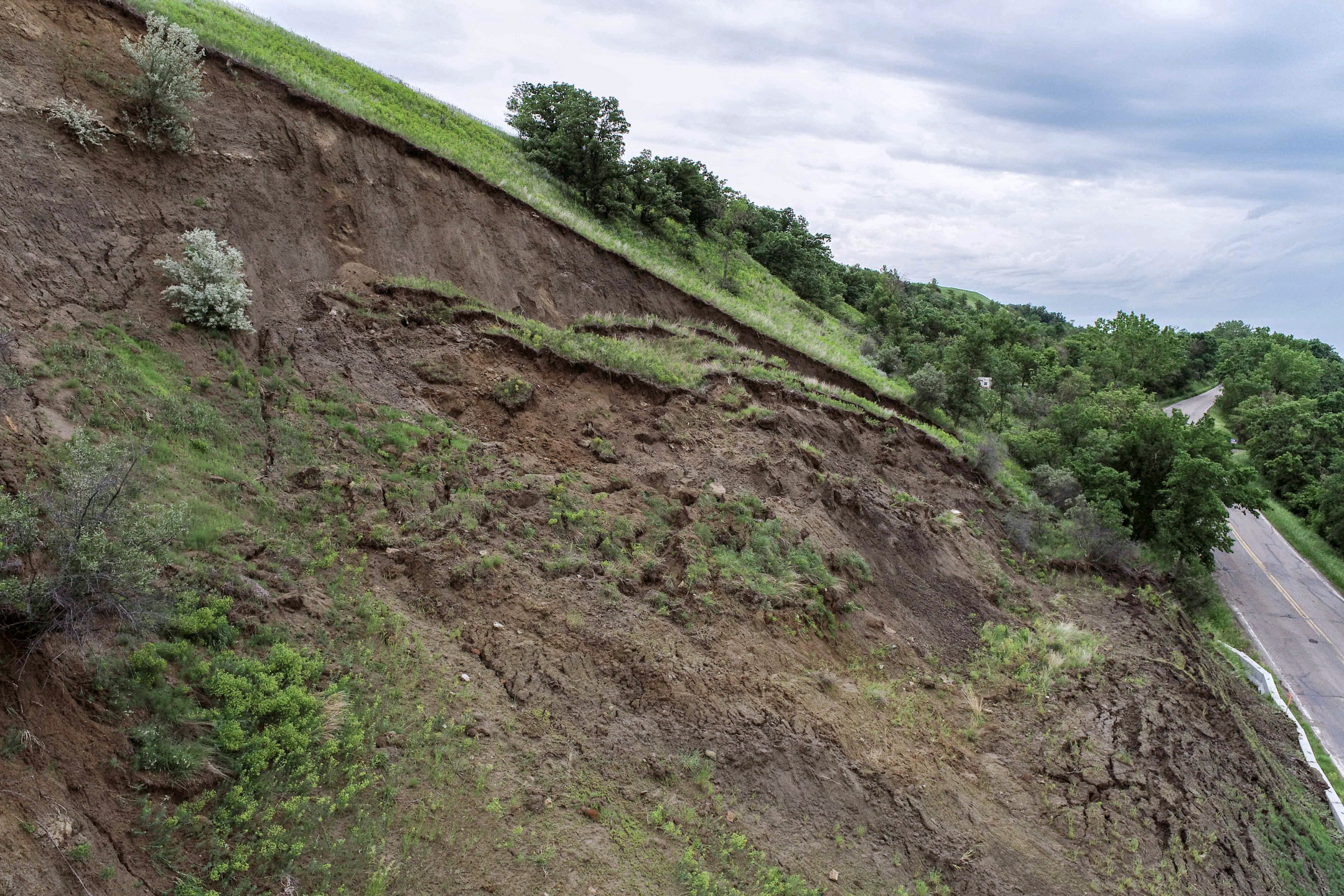 Photograph of a landslide along a paved road.