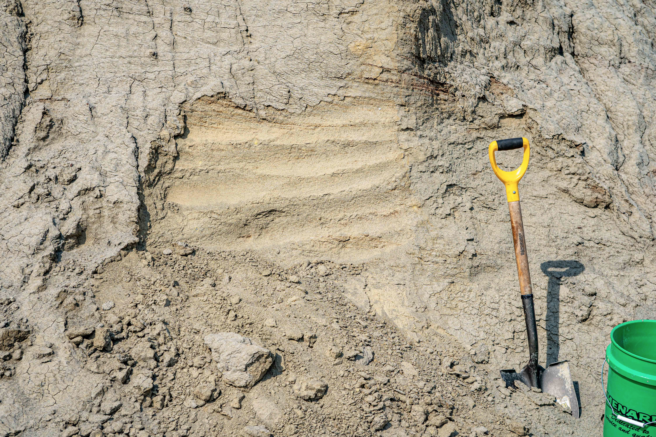 Photo of a shovel, bucket and sand.