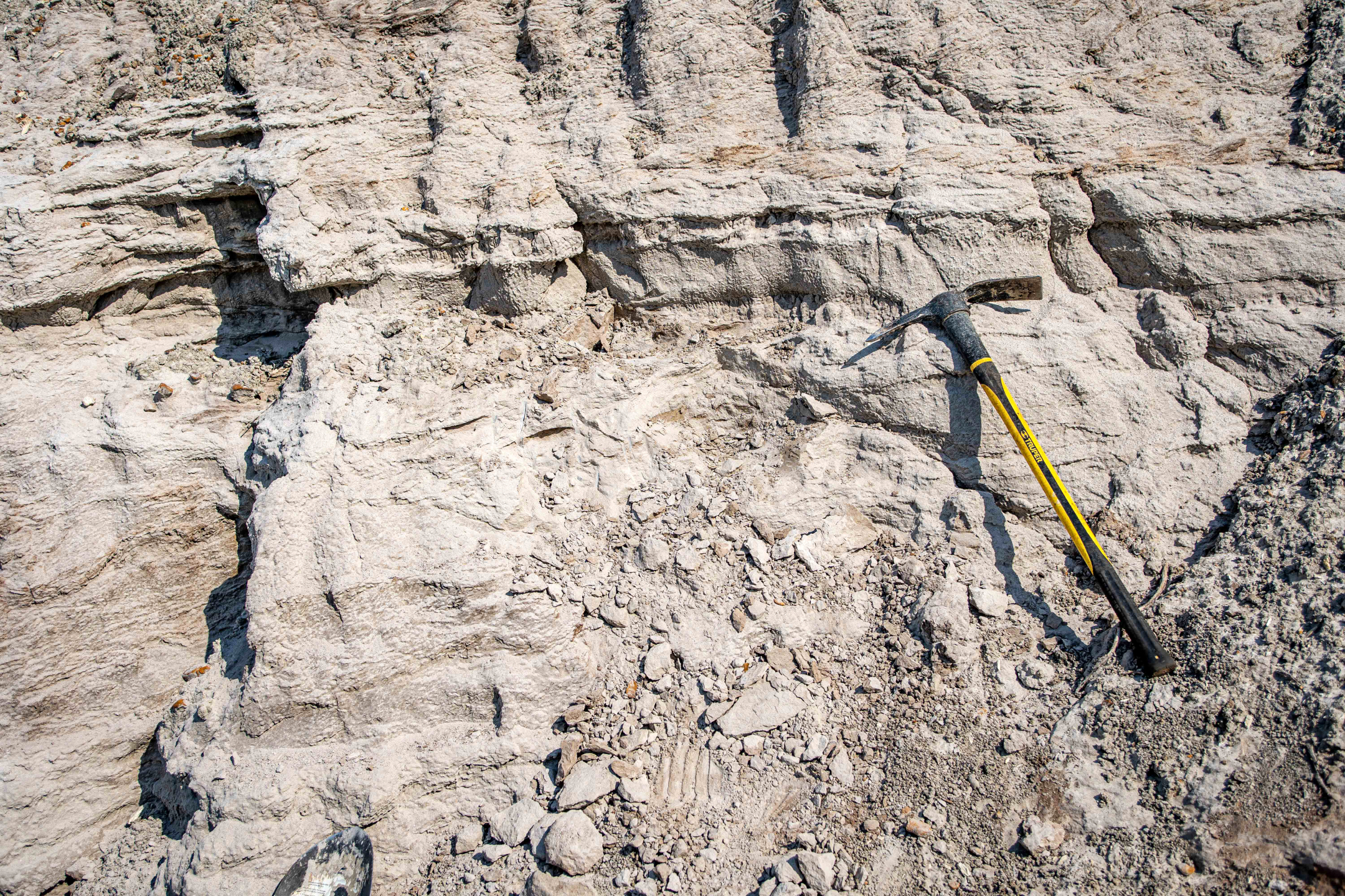 A pick axe leaning against a rock formation.