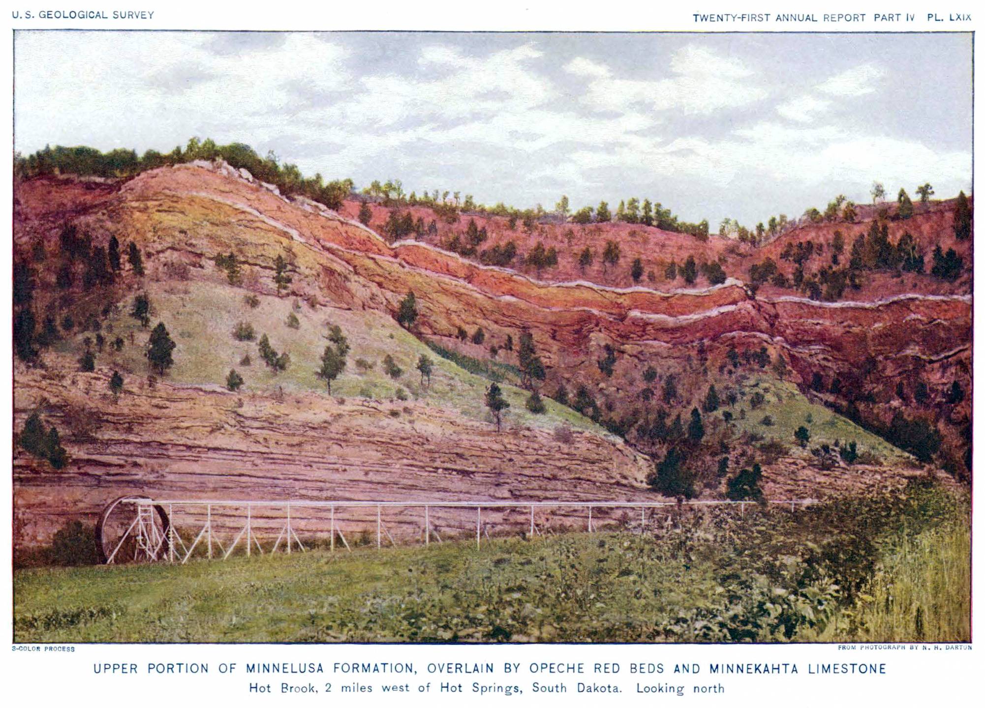 Colored vintage image of a formation of red rocks and a white limestone layer.