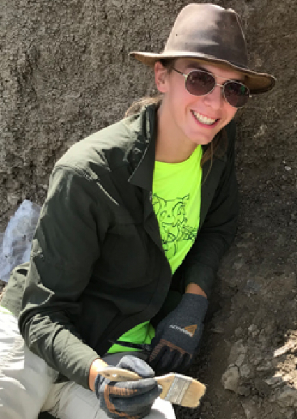 Intern Hayley Orlowski holds a brush in hand at the Bismarck dinosaur site