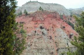 Clinker, the reddish-orange caprock of the hill in the foreground is often used mined for road metal and decorative 
								stone in the southwestern part of the state.(Photo by E. Murphy, NDGS).